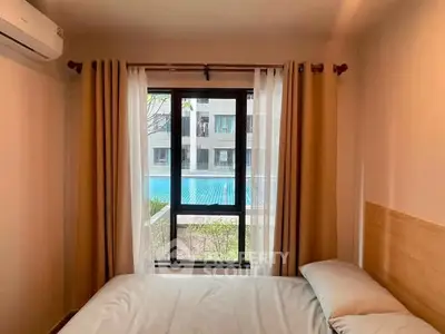 Cozy bedroom with pool view, featuring a comfortable bed and large window for natural light.