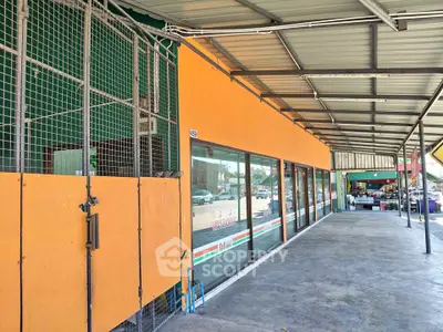 Spacious commercial property with large windows and covered walkway, ideal for retail business.