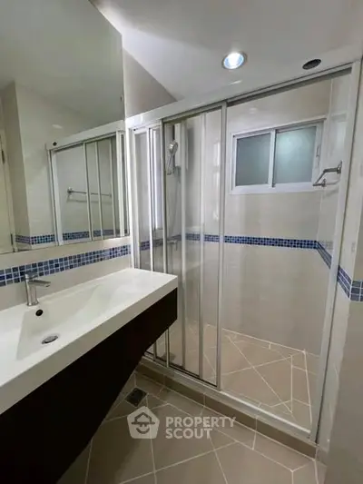 Modern bathroom with sleek shower and stylish sink in contemporary home.