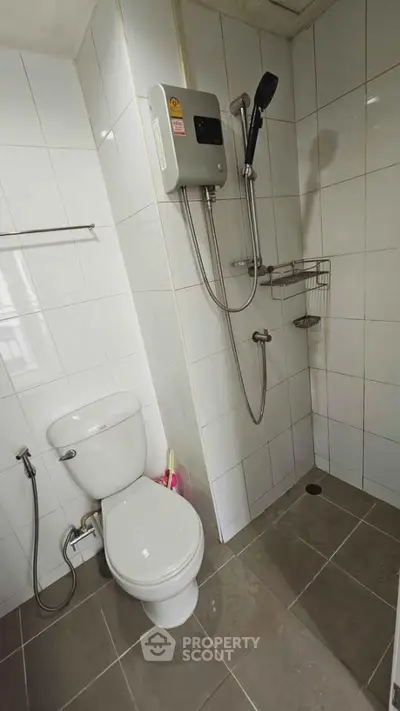 Modern bathroom with shower and toilet in a tiled setting