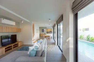 Spacious modern living room with pool view, open layout, and stylish decor.