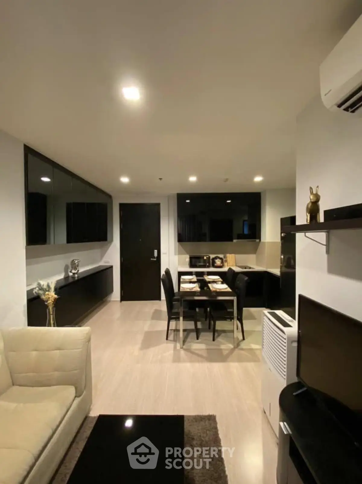 Modern living room with sleek furniture and open dining area in a stylish apartment.