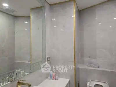 Luxurious bathroom with elegant marble walls and gold accents