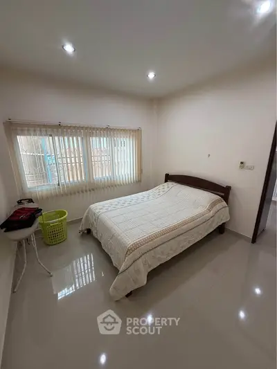 Cozy bedroom with large window and modern lighting