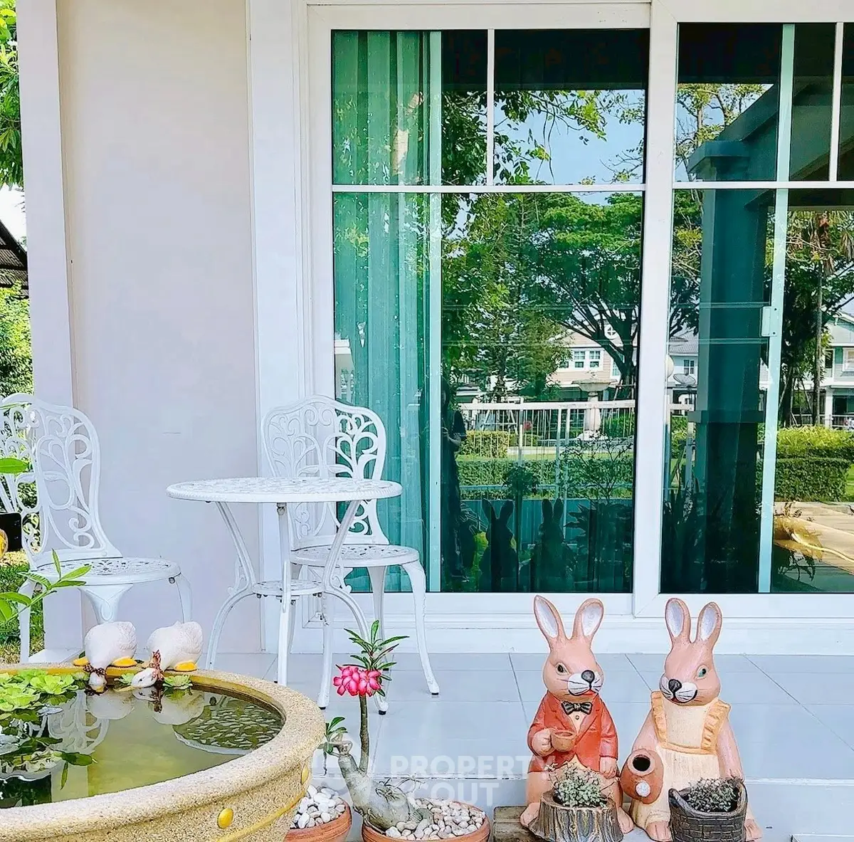 Charming garden patio with decorative rabbits and outdoor seating, perfect for relaxation.