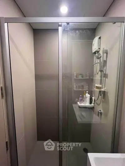 Modern bathroom with glass shower enclosure and sleek fixtures.