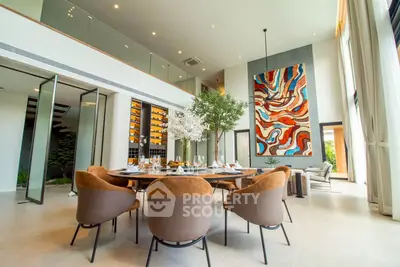 Luxurious modern dining room with high ceilings, elegant decor, and large abstract art piece.