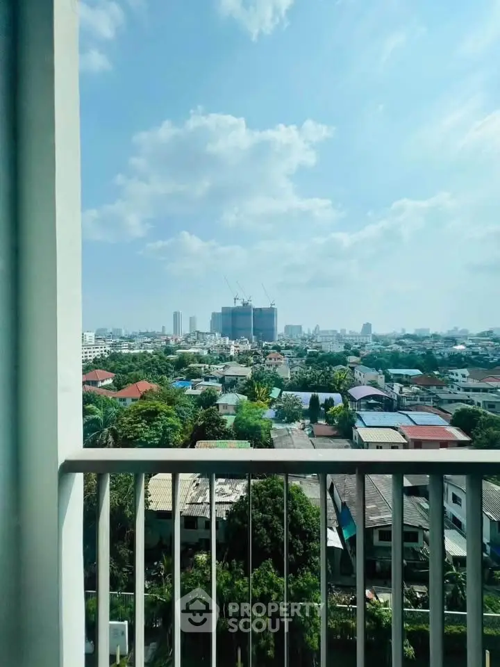 Stunning cityscape view from a high-rise balcony with clear blue skies.