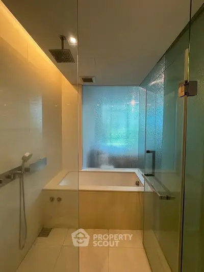 Luxurious modern bathroom with glass shower and bathtub in elegant apartment.
