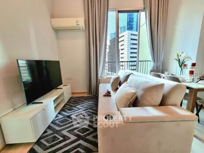 Modern living room with large TV, cozy sofa, and city view from window.