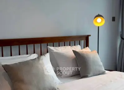 Cozy bedroom with stylish wooden headboard and modern floor lamp