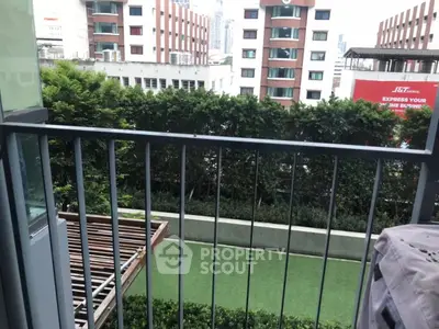 Urban balcony view with lush greenery and cityscape backdrop