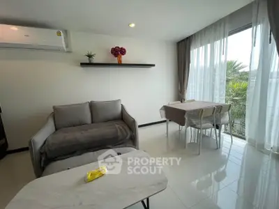 Modern living room with elegant decor and large windows offering natural light and scenic views.