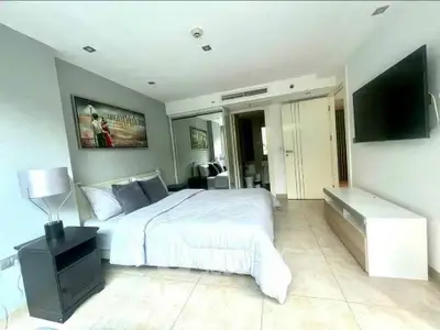 Spacious modern bedroom with stylish decor and wall-mounted TV