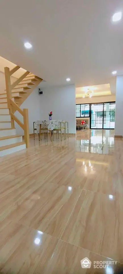 Spacious modern living room with wooden flooring and elegant staircase