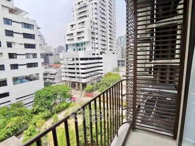 Modern urban balcony with cityscape view and lush greenery