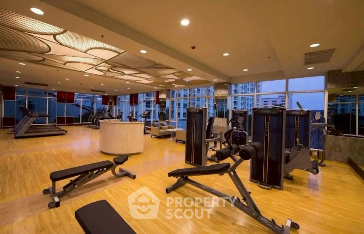 Spacious modern gym with state-of-the-art equipment and city views, perfect for fitness enthusiasts.