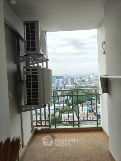 High-rise balcony with cityscape view and air conditioning units.