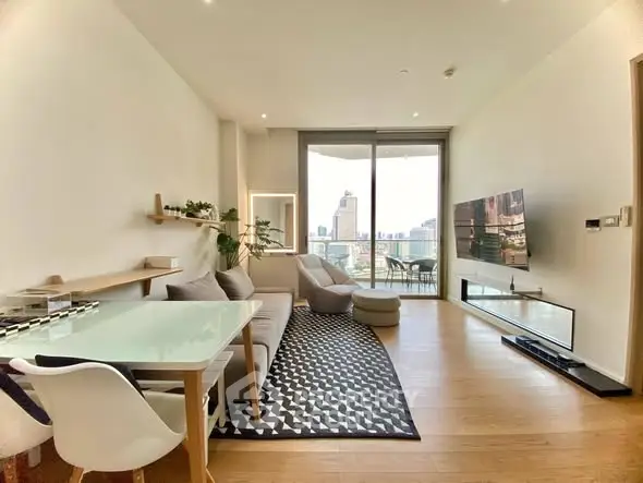 Modern living room with city view, stylish furniture, and large balcony in luxury apartment.