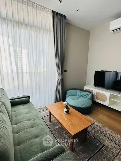 Cozy living room with modern furniture and large window, perfect for relaxation.