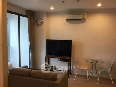 Modern living room with air conditioning, TV, and balcony access in a stylish apartment.