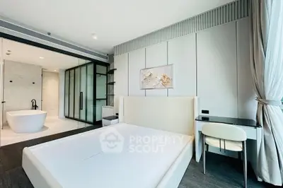 Luxurious modern bedroom with ensuite bathroom featuring a freestanding bathtub and elegant decor.
