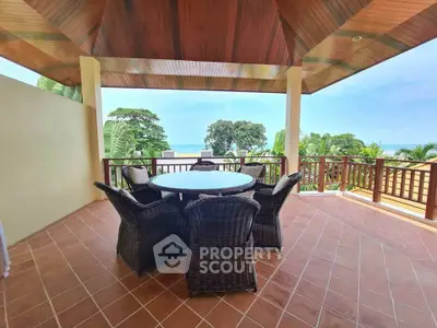 Spacious balcony with ocean view and elegant outdoor seating area.