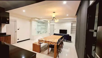 Modern open-layout living room with dining area and stylish lighting in a contemporary apartment.