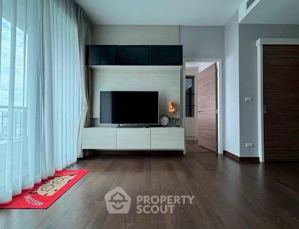 Modern living room with sleek TV setup and wooden flooring
