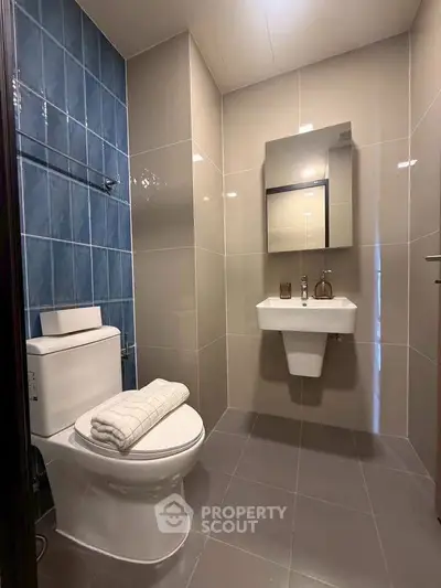 Modern bathroom with sleek fixtures and blue accent tiles, perfect for a contemporary home.