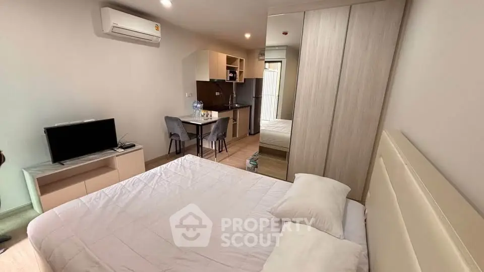 Modern studio apartment with cozy bedroom and compact kitchen, ideal for urban living.