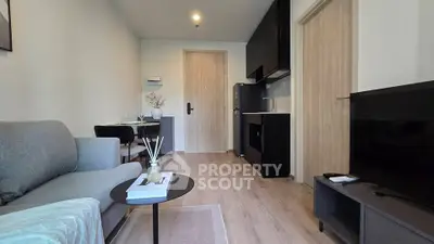 Modern living room with sleek furniture and open kitchen layout in a stylish apartment.