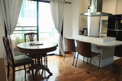 Charming kitchen with open layout and elegant dining area, featuring hardwood floors and modern appliances.