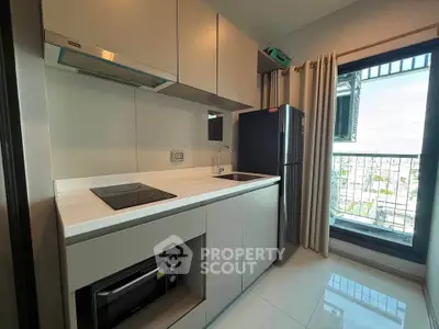 Modern kitchen with sleek design and balcony view in a stylish apartment.