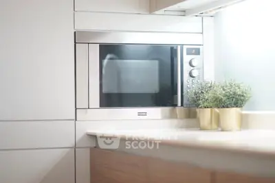 Modern kitchen with built-in microwave and stylish decor