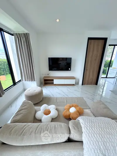 Modern living room with stylish decor and large windows offering natural light
