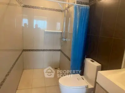 Modern bathroom with sleek shower and toilet in contemporary design.