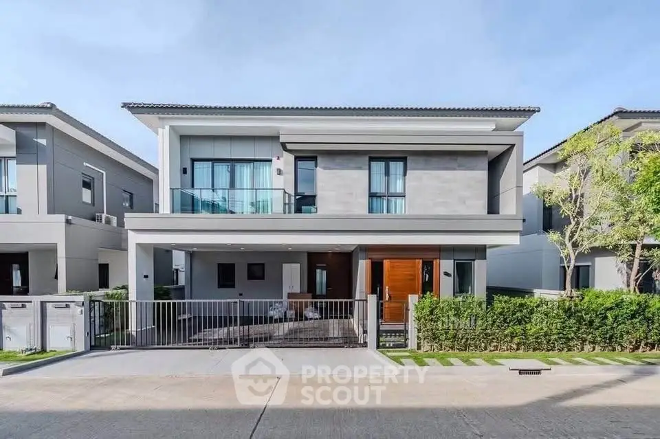 Modern two-story house with sleek design and spacious driveway in a suburban neighborhood.