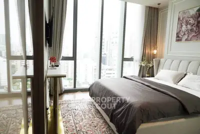 Luxurious bedroom with floor-to-ceiling windows offering stunning city views, elegant decor, and plush bedding.