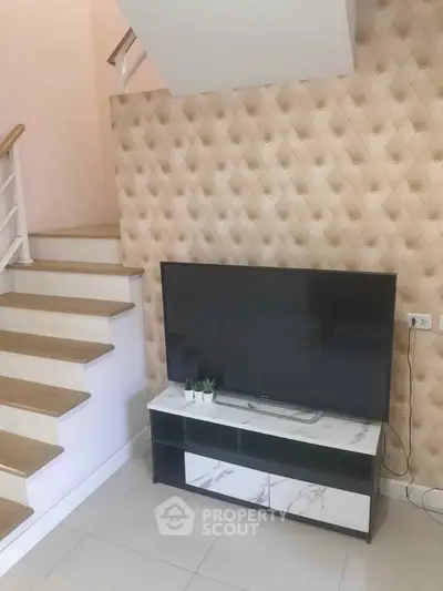 Modern living room with stylish TV stand and staircase