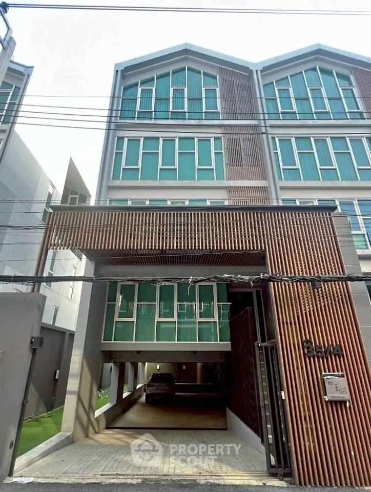 Modern multi-story building with sleek design and large windows, ideal for urban living.