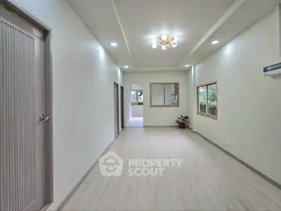 Spacious modern living room with elegant lighting and large windows for natural light.