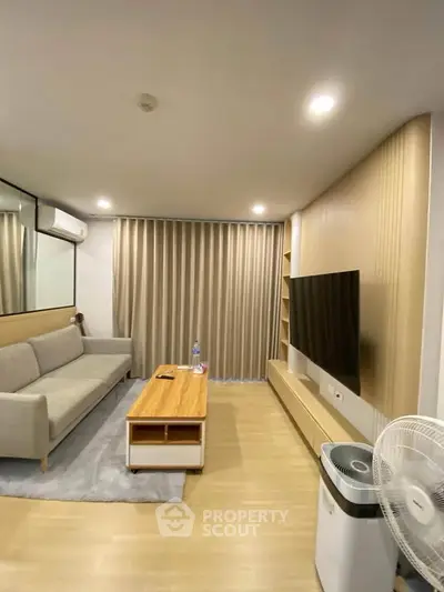 Modern living room with sleek furniture and large TV, perfect for relaxation and entertainment.