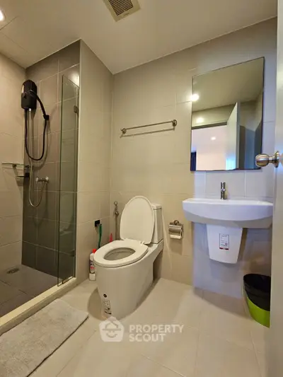 Modern bathroom with glass shower and sleek fixtures in contemporary home.