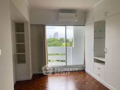 Spacious bedroom with built-in storage and city view balcony