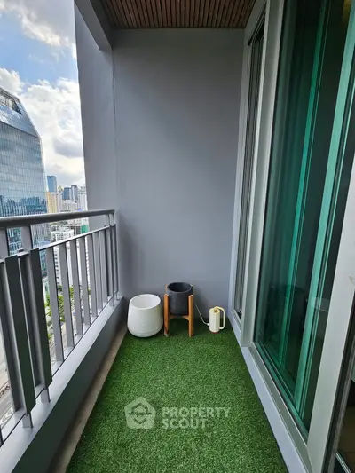 Modern balcony with artificial grass and city view, perfect for relaxation.