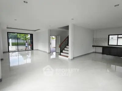 Spacious open-plan living area with modern design and large windows.