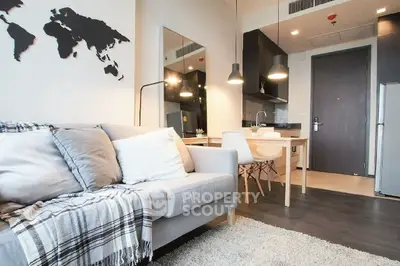 Modern living room with cozy sofa and stylish kitchen in open layout apartment.