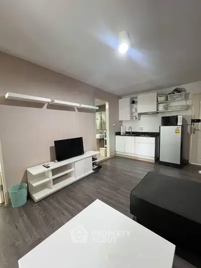 Modern living room with sleek kitchen, open layout, and stylish furnishings.