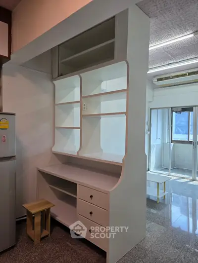 Spacious kitchen with built-in shelving and natural light, perfect for modern living.